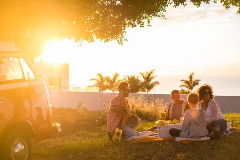 Gezin picknicken in de zon, goedkoop overwinteren