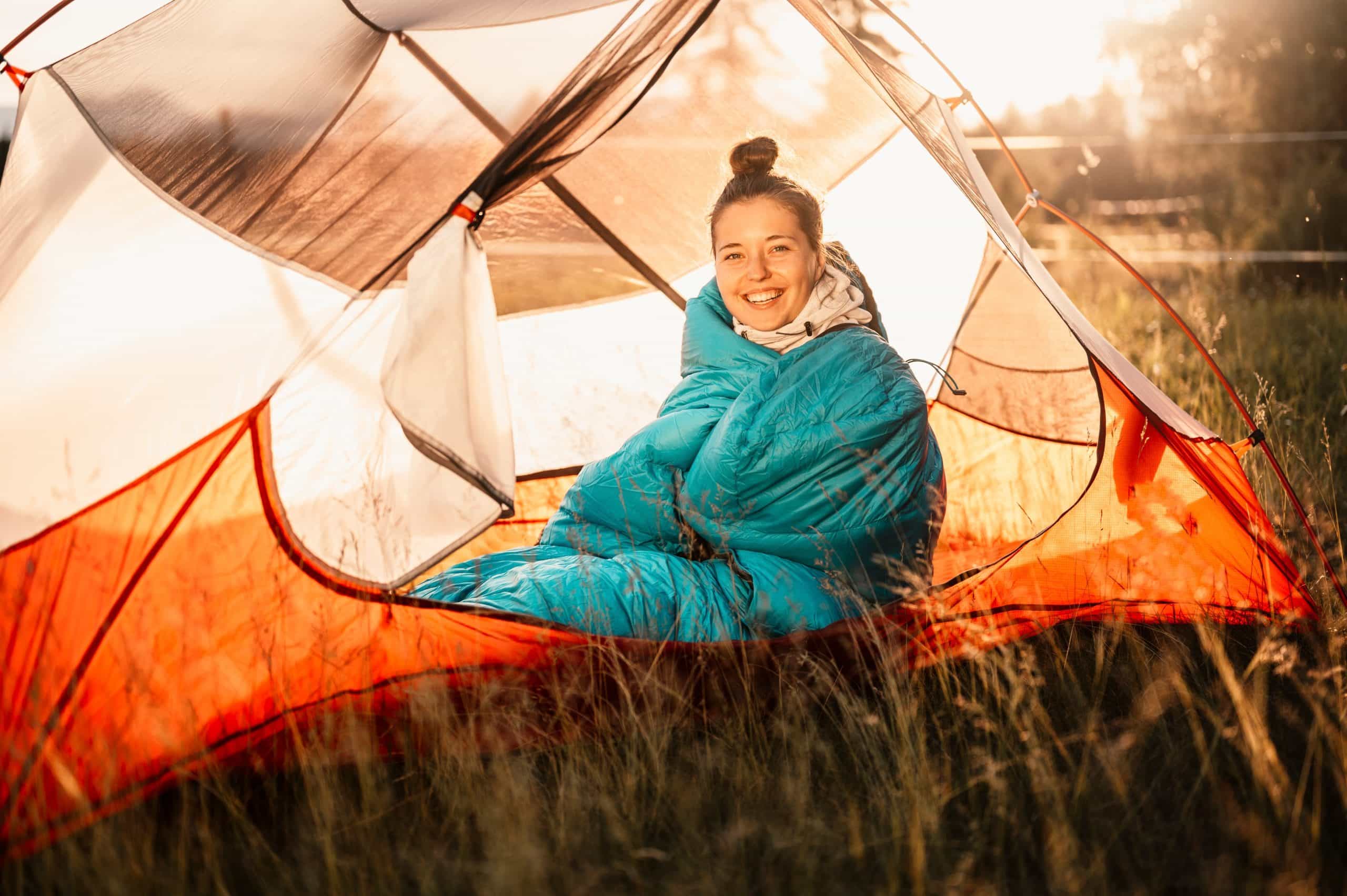 Vrouw in slaapzak in tent