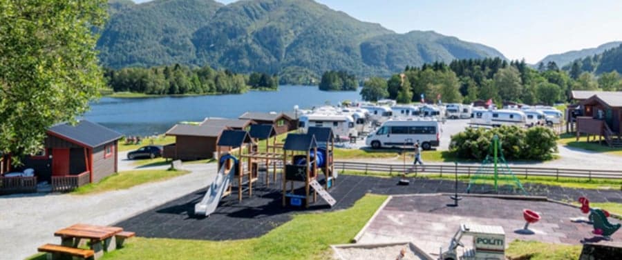 kampeerterrein met speeltuin, campers en uitzciht op de fjorden