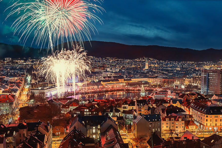 de stad Bergen in het donker met vuurwerk in de lucht